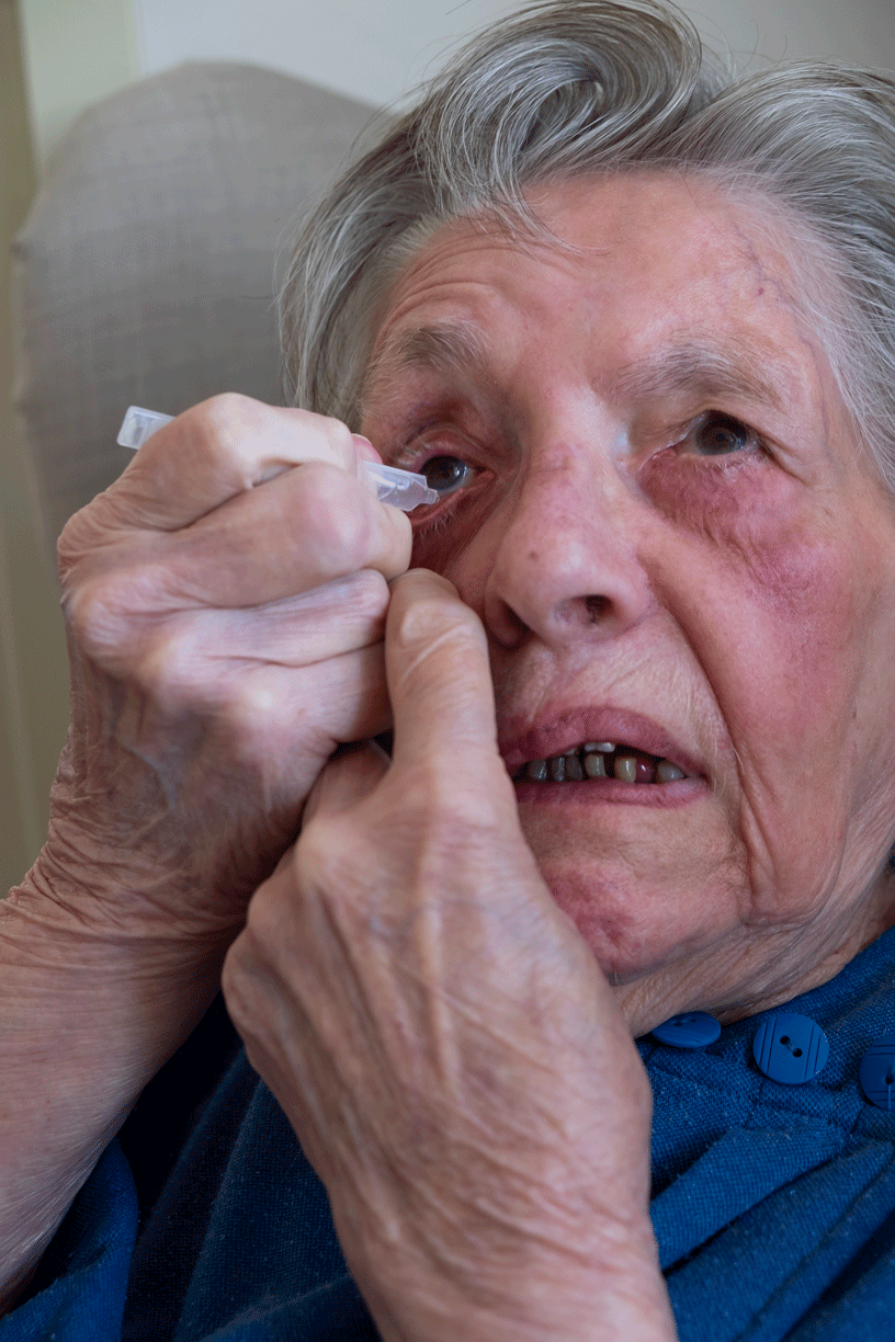 older lady is clean her eyes with eye cleaning water